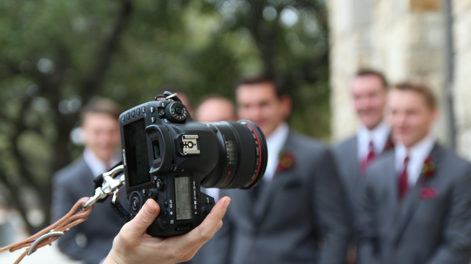 Fotógrafo com a câmera apontada para um grupo de pessoas, representando o momento em que a imagem de alguém é capturada